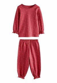 Red cotton pajama set with long-sleeve top and elastic waistband pants, featuring white heart-shaped polka dots and gathered cuffs.