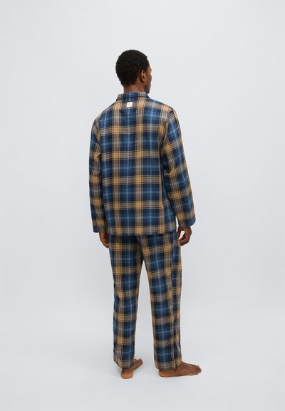 Rutig pyjamaset i blå, gula och svarta toner. Långärmad topp och byxor av mjukt tyg med ledig passform. Märkbart rutmönster.