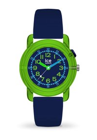 Montre en plastique vert avec un bracelet en silicone bleu marine. Le cadran rond présente des chiffres et des aiguilles bleus sur un fond sombre, avec une couronne en argent.