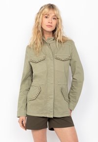 Giacca khaki con colletto, zip frontale e quattro tasche. Presenta dettagli con borchie sulle tasche e sui polsini, realizzata in un tessuto misto cotone.