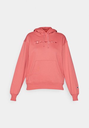 Felpa rosa con cappuccio, dotata di tasca frontale e logo "Champion" ricamato. Presenta polsini e orlo a coste, realizzata in morbido tessuto misto cotone.