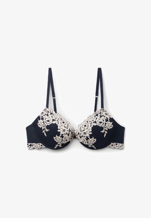 Navy blue bra with floral beige lace detailing on cups and straps; padded underwired design; smooth texture with scalloped edges.
