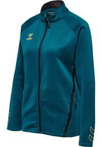 Sportjakke med fuld lynlås i blågrøn med sort lynlås, lynlåslommer i siden, gult hummel-logo på brystet og gule Chevron-designs på ærmerne.