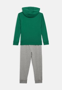 Moletom verde com capuz combinado com calças de moletom cinza claro, exibido de forma plana sobre um fundo branco.