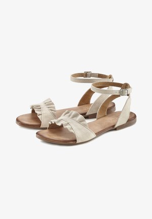 Beige suède sandalen met een gerimpelde voorband, enkelband met gesp en platte houten zool. Open teenontwerp voor ademend vermogen.