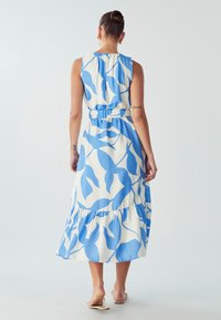 Niebieska i biała, bezrękawnikowa sukienka maxi z kwiatowym wzorem, elastycznym paskiem w talii i warstwowym dołem, wykonana z lekkiego materiału.
