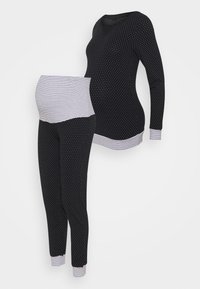 Zwangere lounge-outfit bestaande uit een langslagiste top met stippen en gestreepte accenten, gecombineerd met bijpassende stretchy leggings.