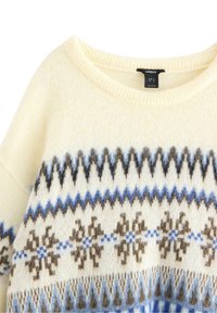 Maglione lavorato a maglia crema con motivo geometrico in marrone, blu e bianco. Presenta un ampio scollo e una finitura testurizzata. Etichettato LINDEX.