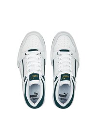 Hvide lædersneakers med grønne accenter, perforeret tåæske og teksturerede sider. Udstyret med et centralt snøresystem og et mærket tunge.
