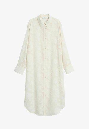 Długa, kremowa sukienka koszulowa z lekkiego materiału, z teksturowanym wzorem w kwiaty, zapinana na guziki z zaokrąglonym dołem.