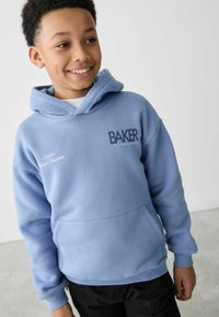 Svijetloplavi dukserica s prednjim džepom, rukavima s manžetama i izvezenim logom "BAKER by Ted Baker" u tamnoplavoj boji. Glatka pamučna mješavina.