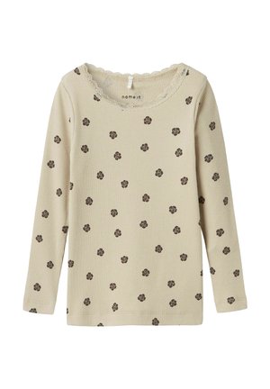 Helles beiges Langarmshirt mit gerippter Textur, das kleine braune Blumenmuster und einen mit Spitze verzierten runden Ausschnitt aufweist.