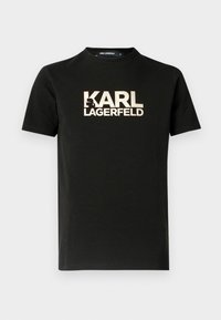 Camiseta negra de algodón con mangas cortas y cuello redondo. Presenta un estampado de logo dorado "KARL LAGERFELD" con un acento de silueta.