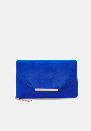 Pochette enveloppe en daim bleu avec un détail de barre fine en or et une sangle partielle en chaîne dorée sur fond blanc.