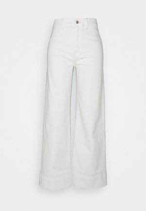 Pantalon blanc taille haute à jambes larges avec fermeture à boutons et zip devant, passants pour ceinture et ourlets pliés.