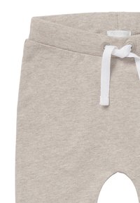 Ljusgrå mjukisbyxor i en mjuk bomullsblandning. Har dragsko i midjan, elastiska muddar och knälappar med slät yta.