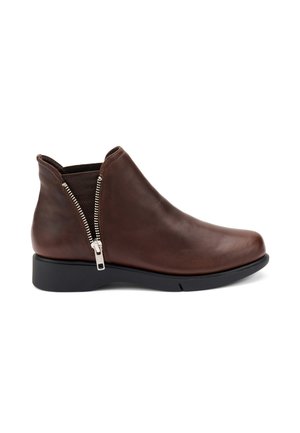 Bottines en cuir marron avec une texture lisse, détail de fermeture éclair sur le côté, talon bas et bout arrondi. Le design est épuré et minimaliste.