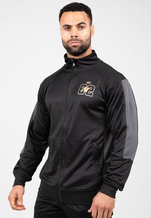 Zwarte zip-up jas met grijze accenten, voorzien van een subtiele logoontwerp. Glad materiaal, ribbelboorden en zijzakken. Atletische pasvorm.