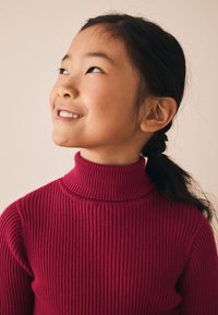 Maglione dolcevita rosso a coste con righe verticali. Il tessuto sembra morbido, leggero e strutturato, adatto a temperature più fresche.