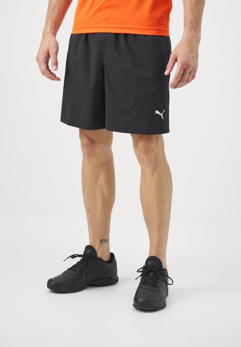 Melni sporta šorti ar gludu tekstūru un elastīgu jostu, ar mazu balto Puma logo. Apvienoti ar melniem čības.