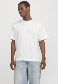 Witte katoenen t-shirt met korte mouwen, voorzien van een klein grijs "Originals" logo op de linkerkant van de borst en een ontspannen pasvorm.