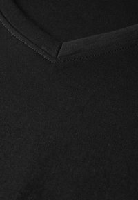 Černé bavlněné tričko s designem do V. Hladká textura, konzistentní barva a zesílené švy na výstřihu. Minimalistický styl.