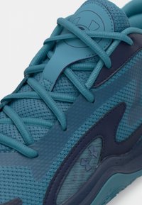Αθλητικό παπούτσι με επάνω μέρος από διαπνέον πλέγμα σε ανοιχτό μπλε, με σκούρες μπλε συνθετικές επικαλύψεις και υφασμένα κορδόνια.