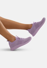 Scarpe da atletica viola con una tomaia in maglia testurizzata, punta arrotondata, chiusura con lacci e suola imbottita, che mostra un mix di tonalità chiare e scure.