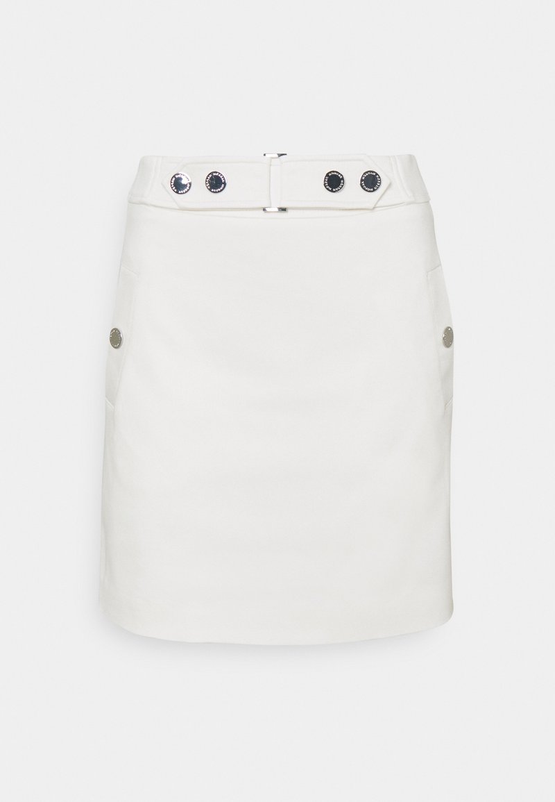 Mini-jupe blanche taille haute, avec quatre boutons noirs sur la ceinture et deux boutons argentés sur les côtés.