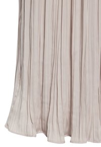 Gonna plissettata in tessuto beige chiaro. Presenta pieghe verticali, una texture liscia e un orlo che si curva dolcemente alla base.