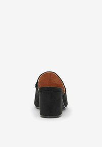 Black suede heeled shoe with a chunky heel, open back, and brown interior lining. Features smooth texture and a rounded toe design.