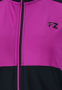 Lila och svart atletisk zip-up jacka med dragkedja, slät tyg och en liten logotyp som tydligt syns på bröstet.