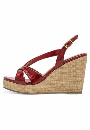 Rode sleehak sandaal van lakleer met een onderkant in strotextuur, uitgevoerd met gekruiste bandjes en een verstelbare enkelriem voor een goede pasvorm.