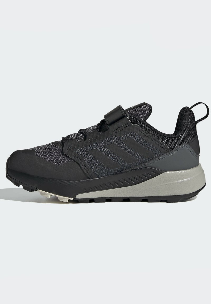 Zapatillas deportivas en negro y gris con parte superior de malla texturizada, tira en el talón y suela resistente diseñada para actividades al aire libre.