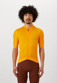 Maillot de cyclisme orange vif en matériau léger, avec une fermeture éclair à l'avant, des manches courtes et un ourlet effilé.