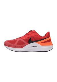 Sneakers atletici rossi con una tomaia in rete, logo Nike swoosh nero, accenti arancioni sul tallone e una intersuola in schiuma bianca.