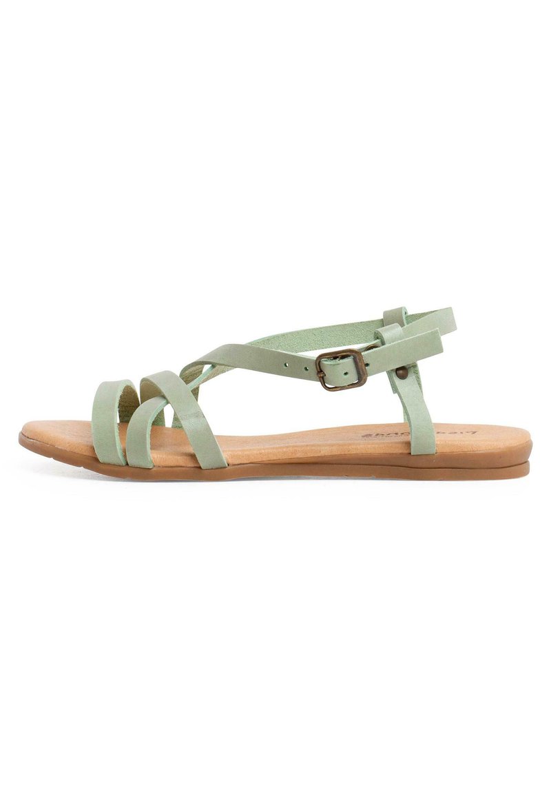 Sandalias planas verdes que cuentan con múltiples correas cruzadas, una hebilla ajustable y una suela de color natural con un acabado suave.