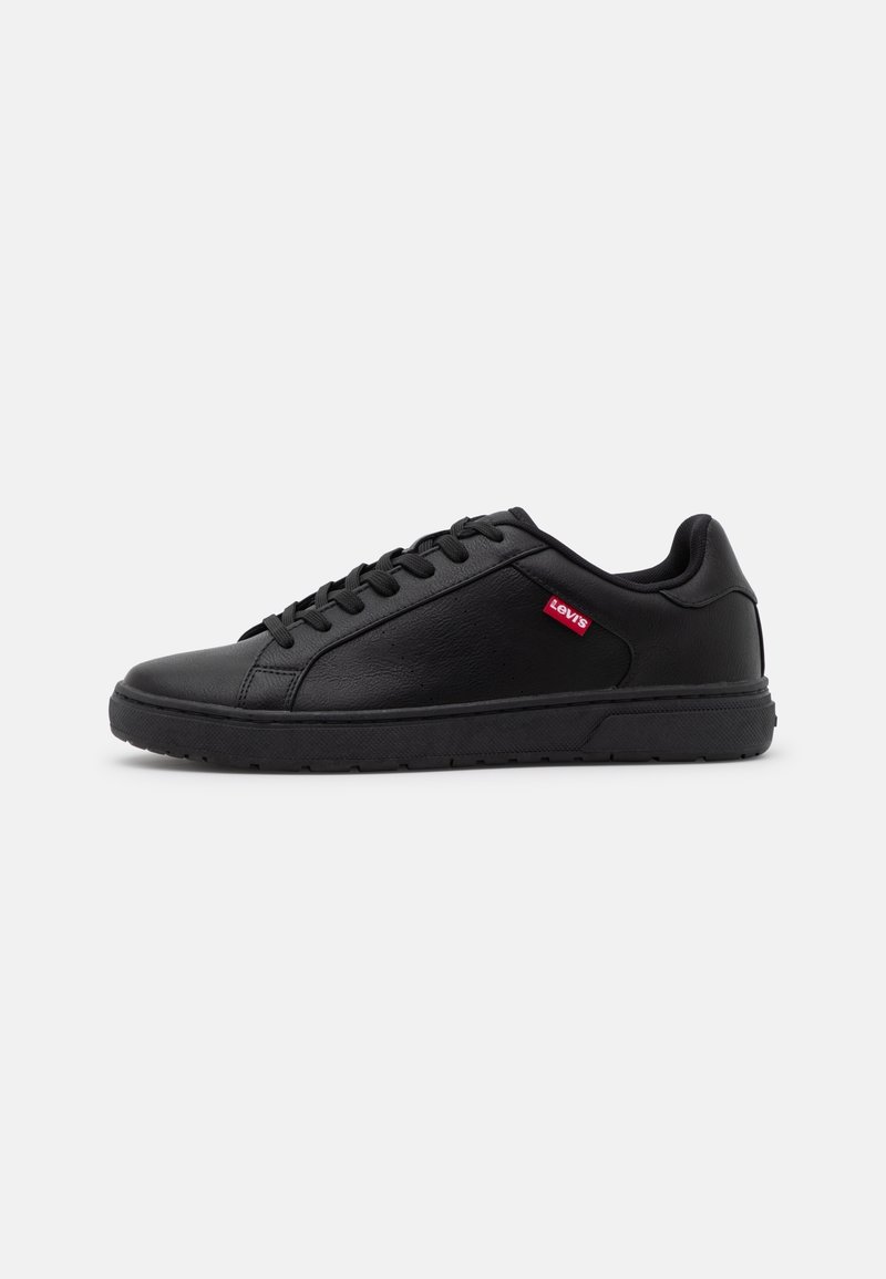 Baskets en cuir noir avec fermeture à lacets, surface texturée, semelle en caoutchouc et petite étiquette rouge Levi's sur le côté.