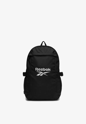Czarny plecak Reebok z przednią kieszenią na zamek, bocznymi siateczkowymi kieszeniami, regulowanymi paskami oraz białym logo Reebok na przednim panelu.