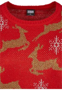Czerwony sweter z dzianiny z wzorem złotych reniferów i białymi płatkami śniegu. Okrągły dekolt z teksturowanym wykończeniem. Wewnątrz widoczna metka.