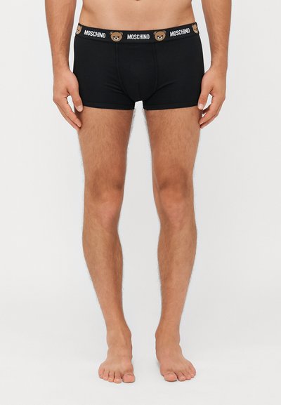 Boxer neri con una fascia con logo che presenta un design di orso. Realizzati in tessuto morbido, con una forma aderente e lunghezza fino a metà coscia.