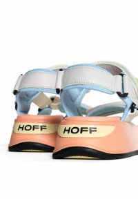 Sandalias deportivas con materiales en blanco, azul y rosa. Cuentan con correas ajustables y una suela negra texturada. Logo "HOFF" en el talón.