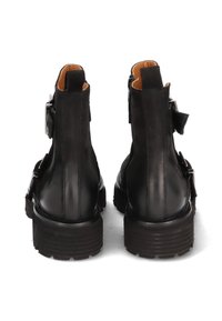 Black leather ankle boots with a matte finish, featuring buckle accents and a chunky sole, displayed from the rear to highlight design details.