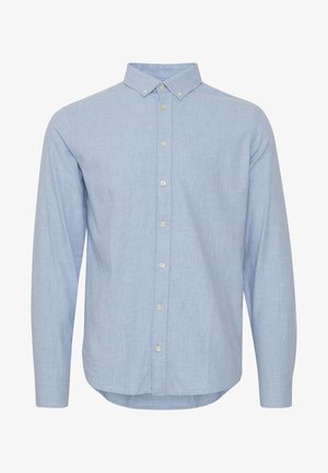 Chemise boutonnée à manches longues de couleur bleu clair en tissu doux. Elle possède un col, un plastron avant avec des boutons et un ourlet incurvé.