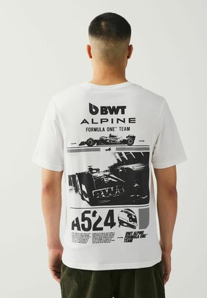 Balta grafika marškiniai su juodais lenktyninių automobilių atspaudais ir tekstu BWT Alpine Formula One Team. Trumpomis rankovėmis ir apvalia iškirpte.