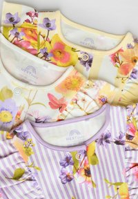 Trois vêtements pour bébés présentant des motifs floraux et des couleurs pastel. Un haut a des rayures, et tous possèdent des encolures rondes avec des fermetures à pression.