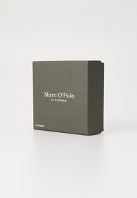 Ciemnoszara prostokątna pudełko o gładkiej fakturze, z białym napisem "Marc O'Polo EST. W STOCKHOLM" oraz "AKCESORIA".