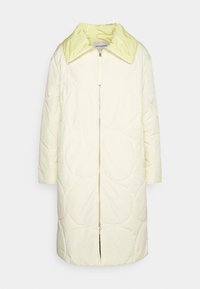 Abrigo acolchado en crema claro con un cuello amarillo pálido en contraste, que cuenta con cierre de cremallera, mangas tres cuartos y textura acolchada.