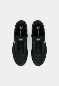 Μαύρα αθλητικά παπούτσια με πλέγμα και συνθετικά επάνω μέρη, με ανάγλυφο σχέδιο, στρογγυλή μύτη και λευκές λεπτομέρειες με λογότυπο στα πλάγια.