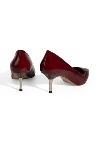 Escarpins en cuir synthétique rouge laqué avec un bout pointu et un talon métallique de 5 cm. Caractéristiques : texture lisse et design à enfiler.